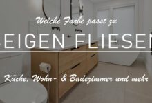 Das Titelbild zeigt ein großes Badezimmer. Die hintere Wand hat zwei Fenster mit geschlosssenen Jalousien. Darunter ein kantige Badewanne mit silberner Amatur. Man erkennt beige Fliesen. Neben der Wanne befinden zwei weiße viereckige Waschbecken mit zwei schwarzen Wasserhähnen. Darüber zwei pillenförmige schwarze Spiegel. Der Schrank darunter ist in einem mittelbraunen Holz gestaltet. Das Bild ist leicht abgedunkelt und darüber der Titel: Welche Farbe passt zu beigen Fliesen?