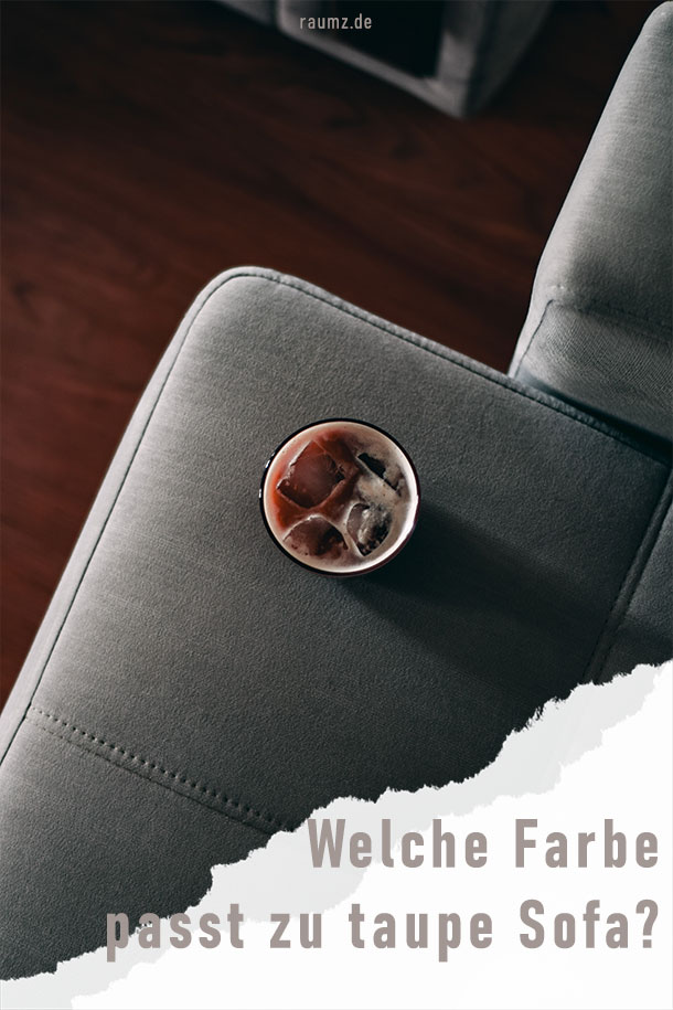 Bild im Hochkant-Format mit der Aufschrift "Welche Farbe passt zu taupe Sofa?". Eine abgerissen Ecke beherbergt die Schrift. Das Bild zeigt eine taupefarbene Sofaecke mit einem Ice Coffee darauf drapiert. Im Hintergrund erkennt man einen rötlich-dunkelbraunen Holzboden.