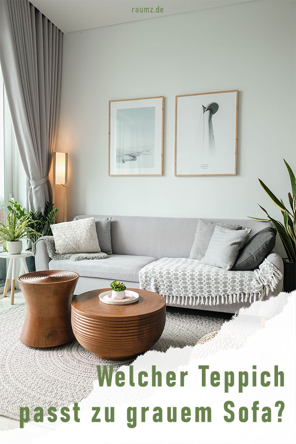 Ausschnitt aus einem Wohnzimmer mit grauem Sofa und grauem Teppich. Dazu werden tiefgrüne Pflanzen und braune Holztische kombiniert. Das Bild ist an der unteren Ecke eingerissen und mit der Schrift "Welcher Teppich passt zu grauem Sofa?" gerahmt.