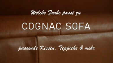 Titelbild des Beitrags "Welche Farbe passt zu cognac Sofa?" Zu sehen ist eine Nahaufnahme von einem cognacfarbenen Sofa. Das Bild ist leicht abgedunkelt, um die Überschrift, den Titel des Beitrags, sowie die Sub-Überschrift "passende Kissen, Teppiche und mehr" lesen zu können.