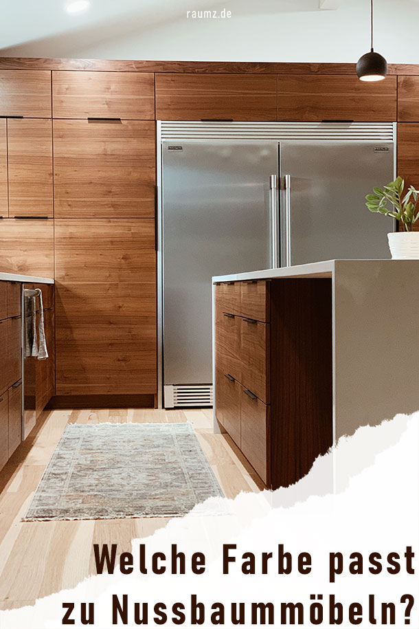 Einblick in eine Küche mit Nussbaum-Akzenten und metallischen Dekorelementen. In der unteren rechten Ecke befindet sich eine abgerissene Ecke mit dem Titel: Welche Farbe passt zu Nussbaummöbeln?