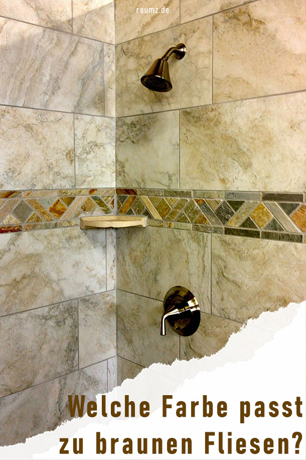 Ein weiterer Ausschnitt aus einer Duschlandschaft. Diesmal ist die Dusche direkt in die Wand mit braunen Fliesen eingelassen. Die Amatur ist in Gold-Bronze gehalten und schmiegt sich in die leicht gemusterten Fliesen. Das Braun wird durch eine Reihe von marmorfarbenen Fliesen unterbrochen. Hier findet man unterschiedliche Töne, von Orange, Burgund, Dunkelbraun bishin zu Grün. An der unteren rechten Ecke ist das Bild eingerissen. In diesem Riss befindet sich der Titel des Bildes: Welche Farbe passt zu braunen Fliesen?