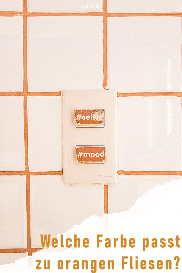 Für eine moderne Kombination hat man die sehr hellen orangen Fliesen mit einem orange-terracottafarbenem Fugenmaterial ergänzt. Damit entsteht ein rustikaler Eindruck. Aufgelockert wird das Rustikale mit beklebten Lichtschaltern, welche mit orangen Hashtag-Stickern versehen sind. Am unteren rechten Eck ist das Bild eingerissen. Hier ist der Titel mit „Welche Farbe passt zu orangen Fliesen?“ zu erkennen.