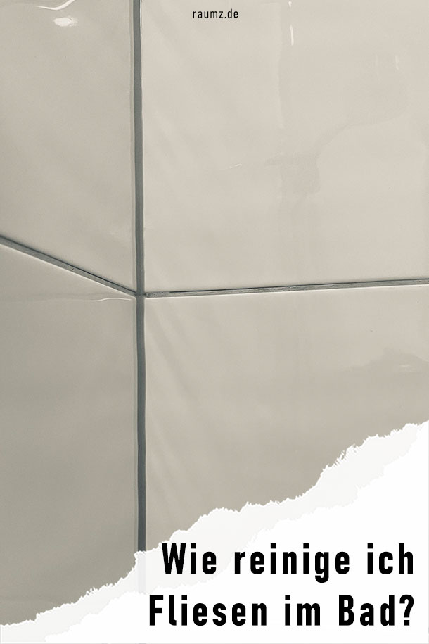 Kleiner Ausschnitt eines Fliesenspiegels im Badezimmer. Das Bild ist ich hochformat und zeigt einen glänzenden Fliesenspiegel, sodass man die Armaturen sehen kann. Das Bild ist in der rechten unteren Ecke eingerissen. Auf dem Riss steht der Titel des Bilds: "Wie reinige ich Fliesen im Bad?"